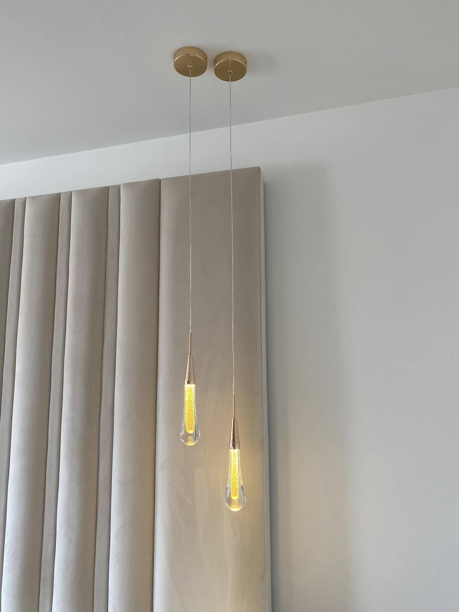 Gold teardrop pendants hung either side of a bed