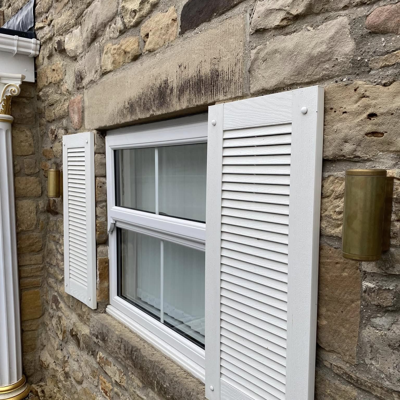 Brass up-and-down lights on a stone cottage